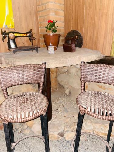 two wicker chairs sitting in front of a stone table at Sítio Estrela da Manhã Hospedagem e Lazer in Palmeiras