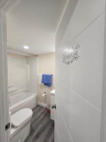 a white bathroom with a toilet and a bath tub at Stormwater Haven in Winnipeg