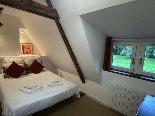 a bedroom with a bed with red pillows and a window at Clos de Leger in Pleine-sève