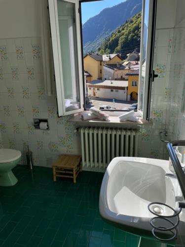 ein Badezimmer mit Waschbecken und Fenster in der Unterkunft La maison V in Pontebba