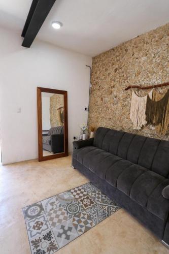 a living room with a black couch and a mirror at Departamento en San Sebastián Mérida in Mérida