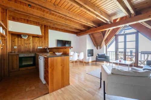 a kitchen and living room with a couch and a table at Abuhardillado con preciosas vistas in Cerler