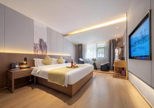 a bedroom with a large bed and a flat screen tv at 归源臻品酒店 in Hanqiyu