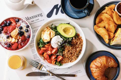 a table with a bowl of food and plates of bread at Tempo By Hilton Raleigh Downtown in Raleigh