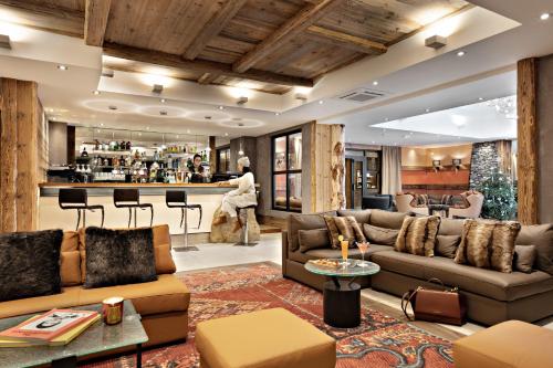 a living room with couches and a bar at MGM Hôtels & Résidences - Résidence Alexane in Samoëns
