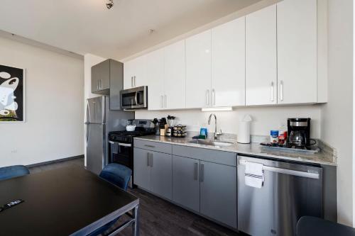 a kitchen with white cabinets and a counter top at 2BR City Loft Amazing Glass Views in Chicago