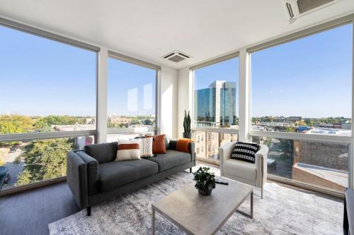 a living room with a couch and large windows at 2BR City Loft Amazing Glass Views in Chicago