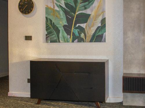 a black cabinet with a clock on a wall at Leork Hotel in Rawalpindi