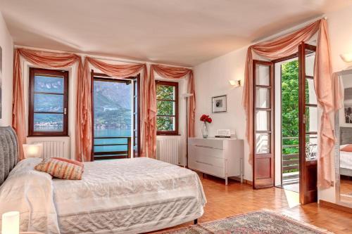 a bedroom with a bed and large windows at Villa Il Cigno Lakeside in Oliveto Lario
