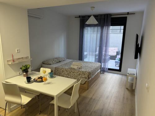 una piccola camera con tavolo, letto, tavolo e sedie di A&R Fuerteventura 006 a San Sebastián de los Reyes