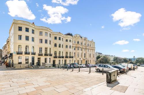 Un gran edificio con coches aparcados delante. en Brighton 2 Bed Brunswick, en Brighton & Hove