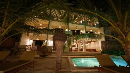 a resort with a swimming pool and a palm tree at Tangawizi Lodge Zanzibar - Adults Only in Jambiani