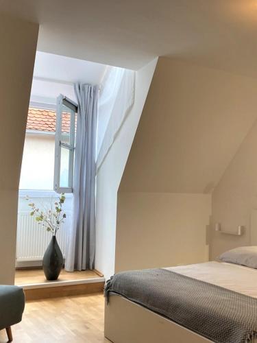 a bedroom with a bed and a window with a vase at Carillon by BestChoice - Old City - Self Check-in with PARKING option in Graz