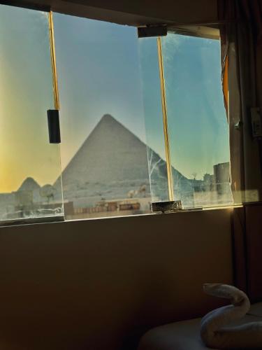 a view of the pyramids from a bedroom window at Thoth pyramids view hotel in Cairo