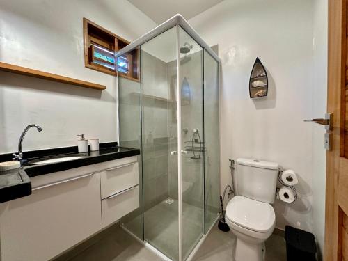 Un baño con inodoro y ducha de cristal. en Casa maléa, en Amontada