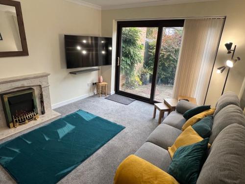 a living room with a couch and a fireplace at Superb Comfy 2 Bed House, Responsive & Caring Hosts Free WiFi & Parking, Close to MK Centre, Train Station, Santander, Network Rail by Webbhill Stays in Milton Keynes