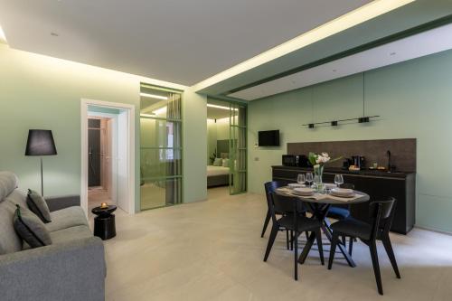 a dining room and living room with a table and chairs at Casa Foligno by Hili in Rome