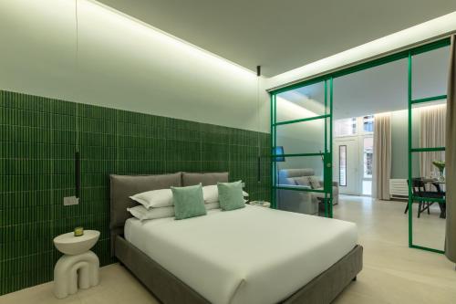 a bedroom with a white bed and a green wall at Casa Foligno by Hili in Rome