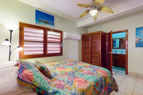 a bedroom with a bed and a ceiling fan at Hibiscus @ Caribe Island in San Pedro