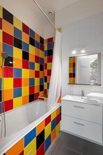 a colorful bathroom with a tub and a sink at Studio Saint Rémy Dieppe in Dieppe