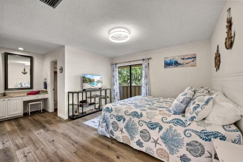 a bedroom with a bed and a desk and a window at Coastal Condo, Water Views, Fishing Dock & 0.6 Miles to Siesta Beach in Siesta Key