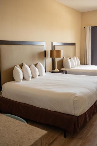 a hotel room with two beds with white pillows at The Citrus Hotel in Tavares