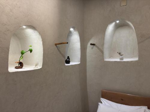 a bedroom with three shelves on the wall with a plant at بيت الصباح نزل وكافيه Bait AlSabah Heritage Inn & Cafe in Birkat al Mawz