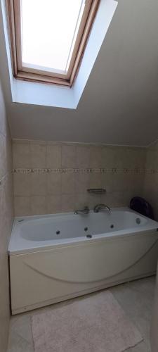 a large white bath tub in a bathroom with a skylight at Holiday Home Ploski in Herceg-Novi