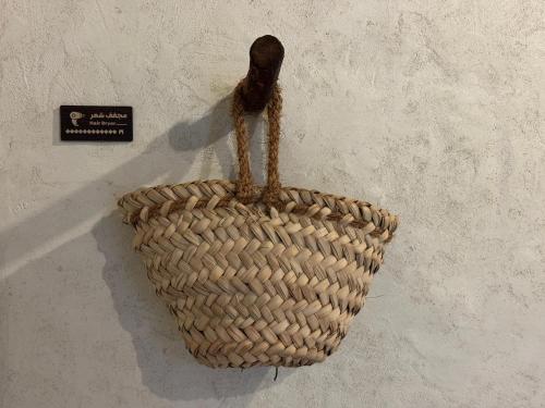 a wicker basket hanging on a wall at بيت الصباح نزل وكافيه Bait AlSabah Heritage Inn & Cafe in Birkat al Mawz
