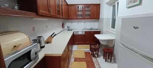 a small kitchen with wooden cabinets and a sink at Holiday Home Ploski in Herceg-Novi