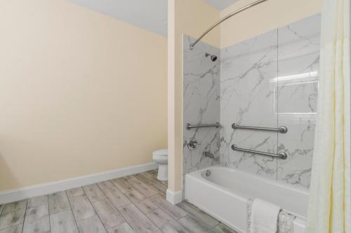 a bathroom with a white tub and a toilet at Americas Best Value Inn & Suites-Livingston in Livingston