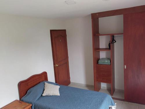 a bedroom with a bed and a wooden cabinet at Entire apartment on Av Tollocan in Toluca