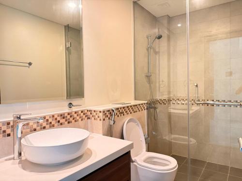 a bathroom with a sink and a toilet and a shower at Chic City Retreat Reva Residences Business Bay in Dubai