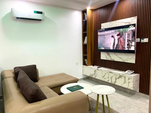 a living room with a couch and a flat screen tv at De Emerald Hotel & Apartments in Atan