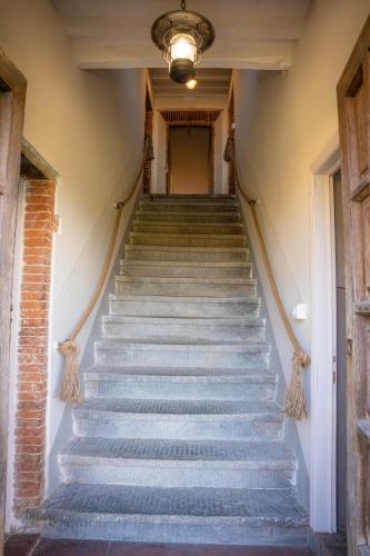 a set of stairs in an old building with a chandelier at Le Chiome in San Giovanni Alla Vena