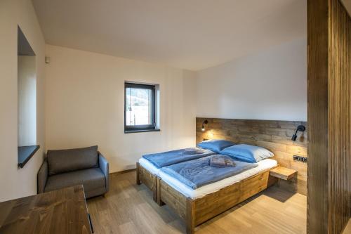 a bedroom with a bed and a chair at Chalet Lucie in Bedřichov