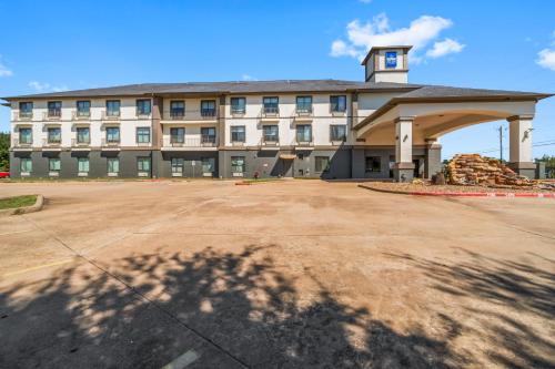 a large building with a parking lot in front of it at Americas Best Value Inn & Suites-Livingston in Livingston
