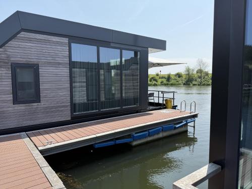 a house on a dock on a body of water at De Maasterp - woonboot 14 in Montfort