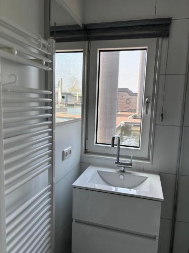 a bathroom with a sink and a window at De Maasterp - Watervillage 14 in Ohé en Laak