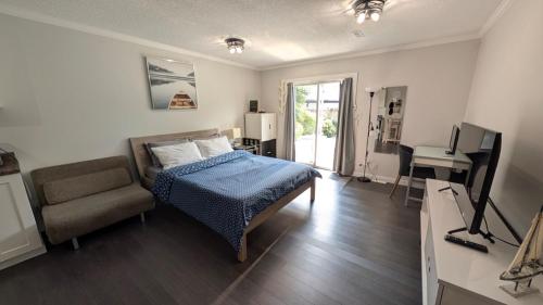 a bedroom with a bed and a chair and a desk at Modern unit on Burke Mountain - FIFA 2026 in Port Coquitlam