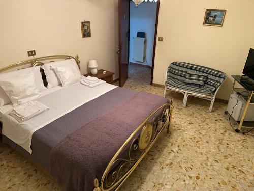 a bedroom with a large bed and a chair at Casa della zia rosa in Valentano