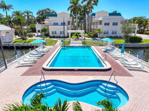 a swimming pool at a resort with chairs and a building at Palm Bay Club By Beachside Management in Siesta Key