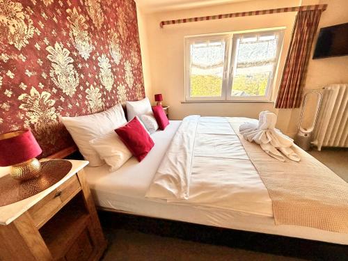 a bedroom with a large white bed with a window at Hotel Elisabeth Ilse in Braunlage