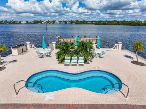 a swimming pool next to a body of water at Palm Bay Club By Beachside Management in Siesta Key