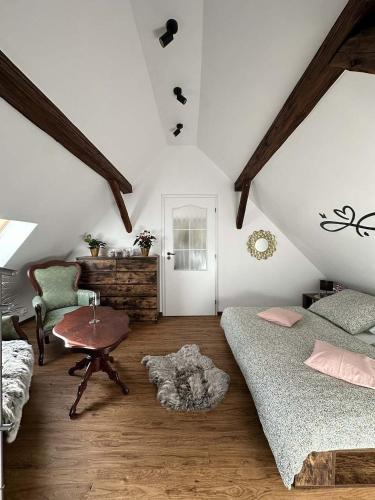 a attic room with two beds and a table at Statek Březina in Březina