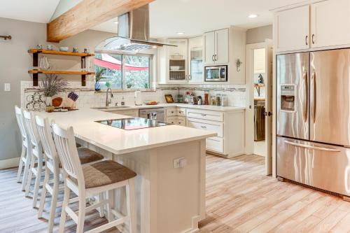 a kitchen with white cabinets and a large island with bar stools at Gorgeous San Marco Home with Patio and Grill! in San Marcos