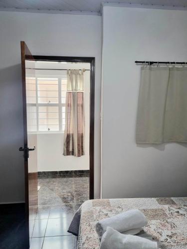 a bedroom with a bed and a window at Pousada Jandi in São Miguel Arcanjo