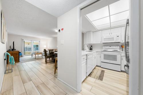 a kitchen with white appliances and a dining room at Palm Bay Club By Beachside Management in Siesta Key