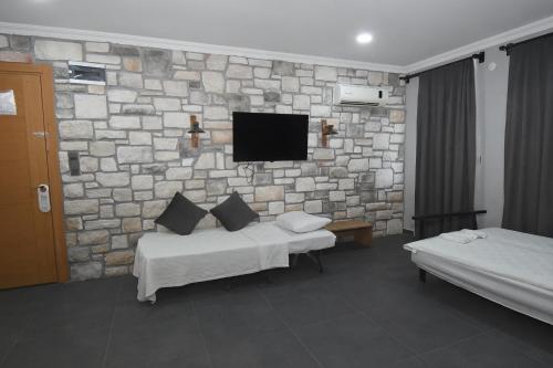 a hotel room with two beds and a stone wall at Ballı Butik hotel in Kayakoy
