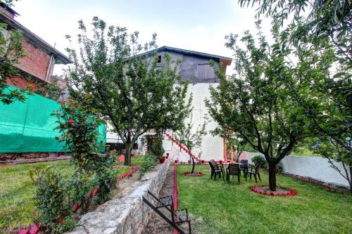 a garden with trees and tables and chairs at Hotel Mountain face by Snow City Hotels in Manāli